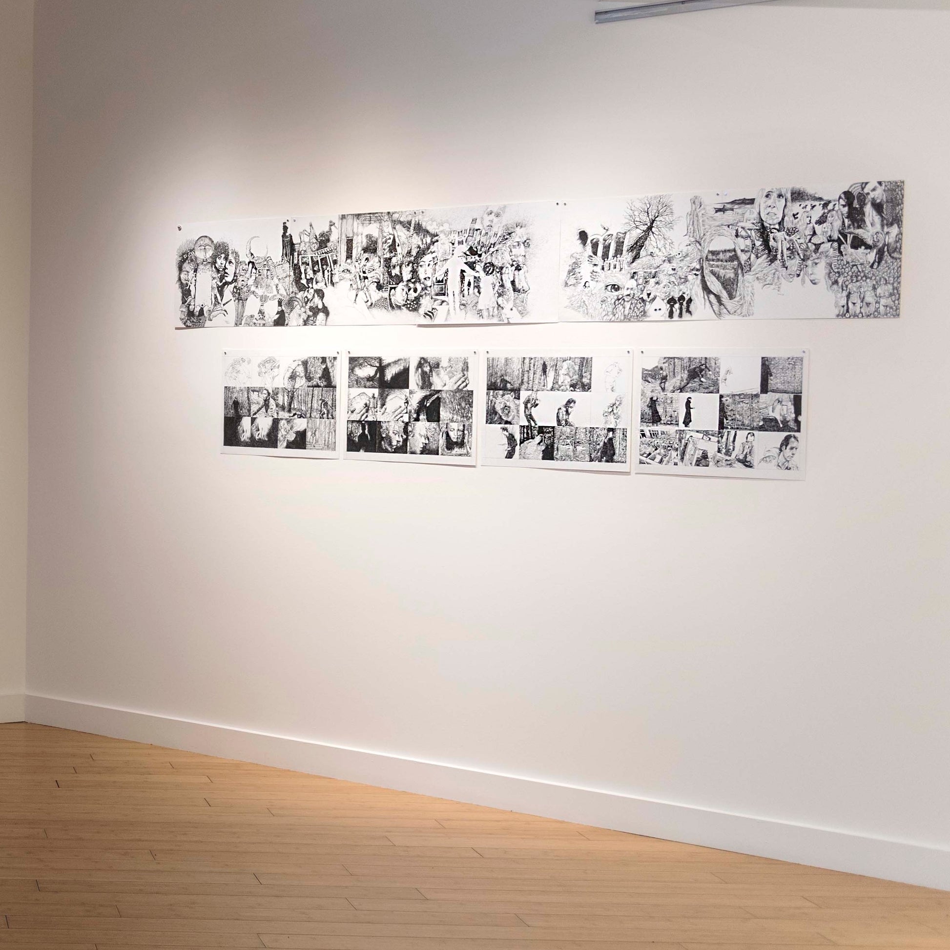 Exhibition display of graphic novel panels, featuring ink drawings, disoriented people, woods, leaves and movement.