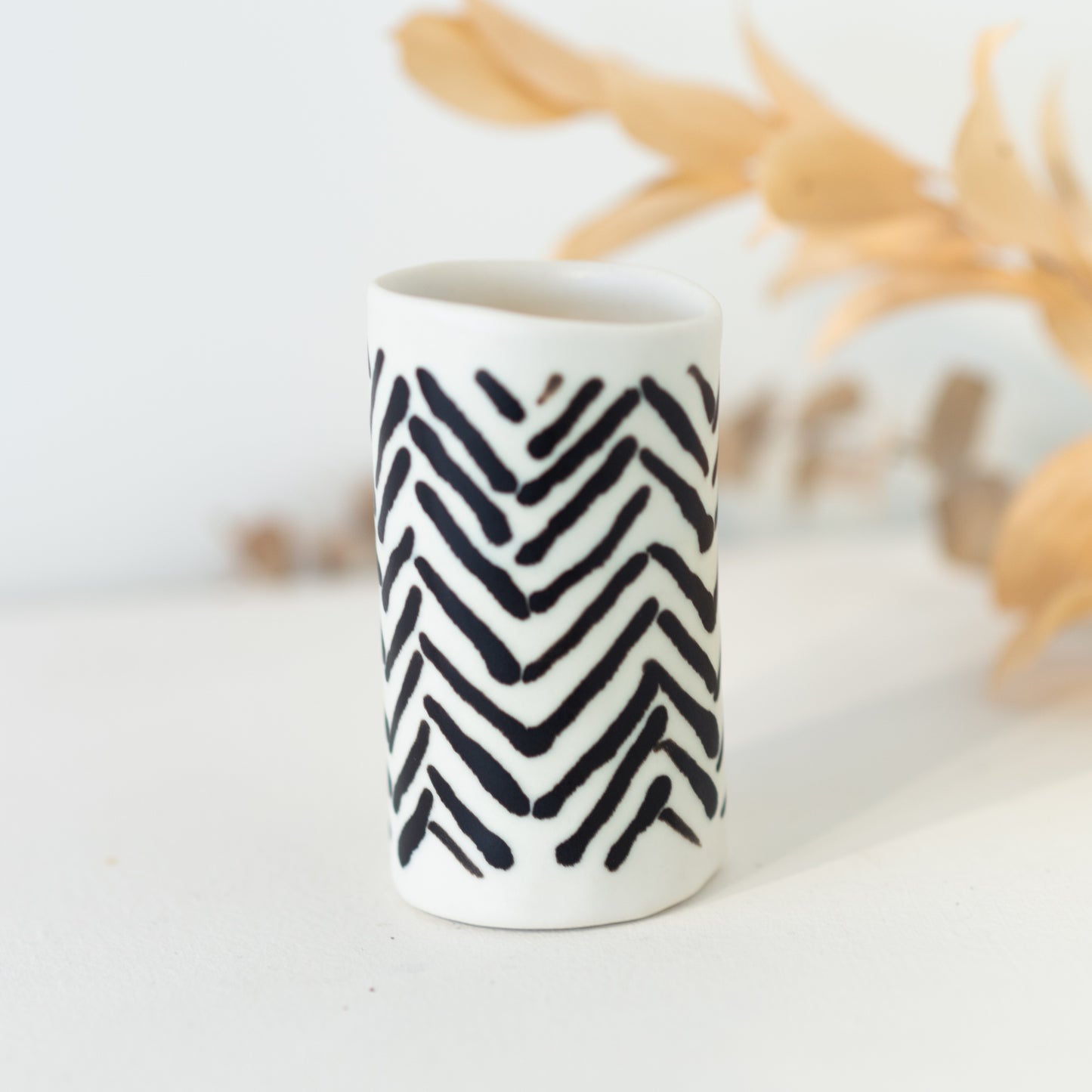 White vase with black chevron patterning.