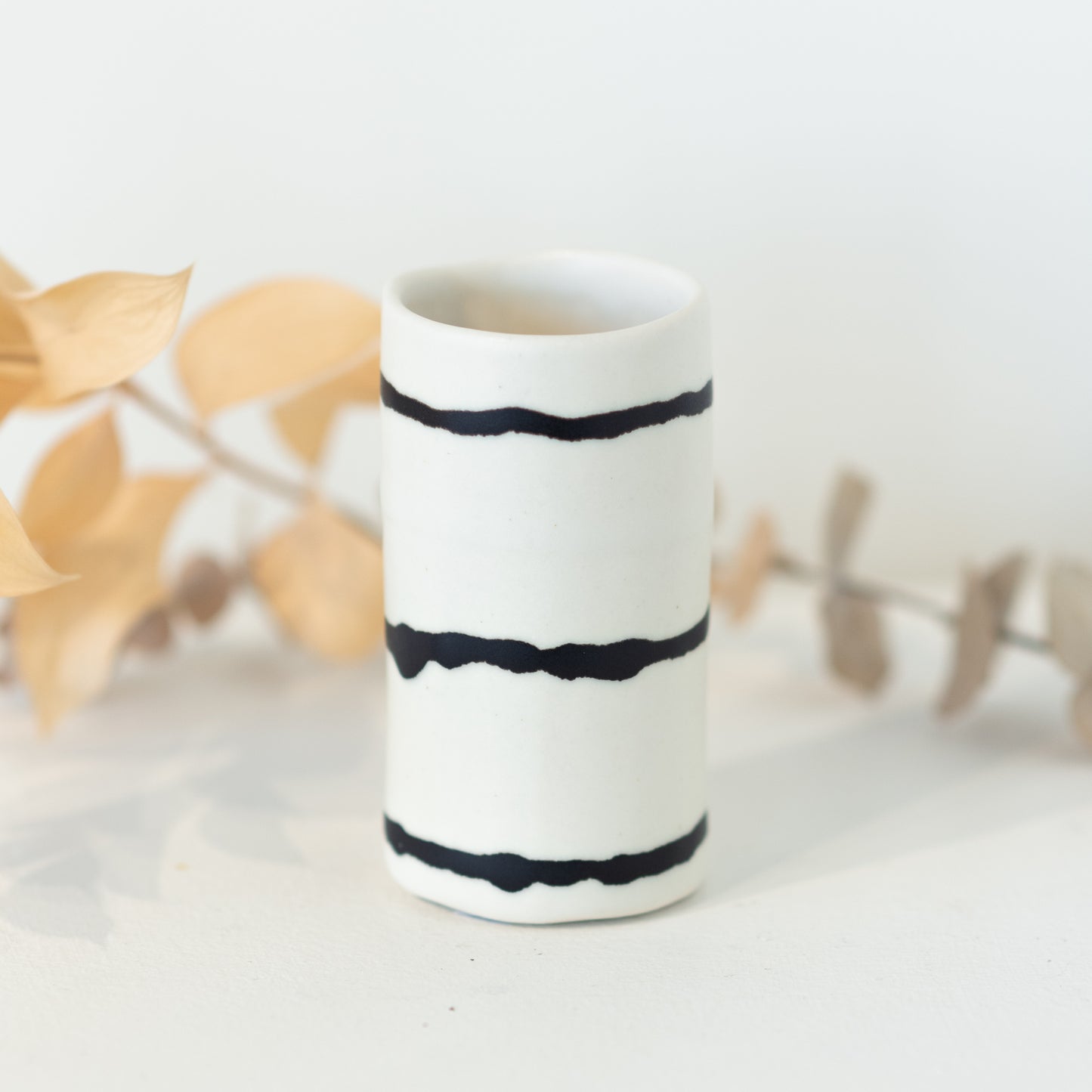 White vase with black irregular horizontal lines